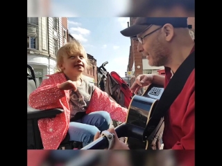 Seven year old blind girl plays the guitar with busker