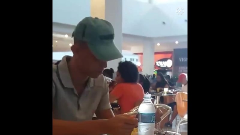 Работник фуд корта помогает инвалиду есть