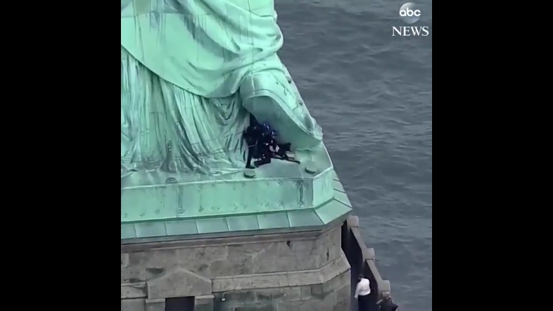 Woman who scaled base of statue of liberty detained by authorities, led back down