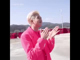 A clapping and smiling joonie in his pink suit