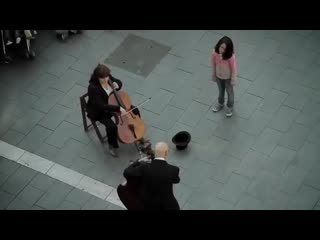 A little girl gives a coin to a street musician and gets the best surprise in return