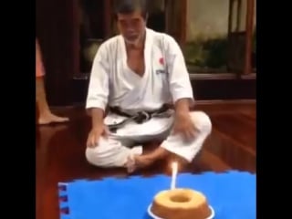 70 летний мастер карате задувает свечу на торте в свой день рождения