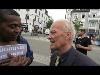 Moslem aus eritrea diskutiert mit afd landtagsabgeordnetem uli henkel bei mahnwache in münchen