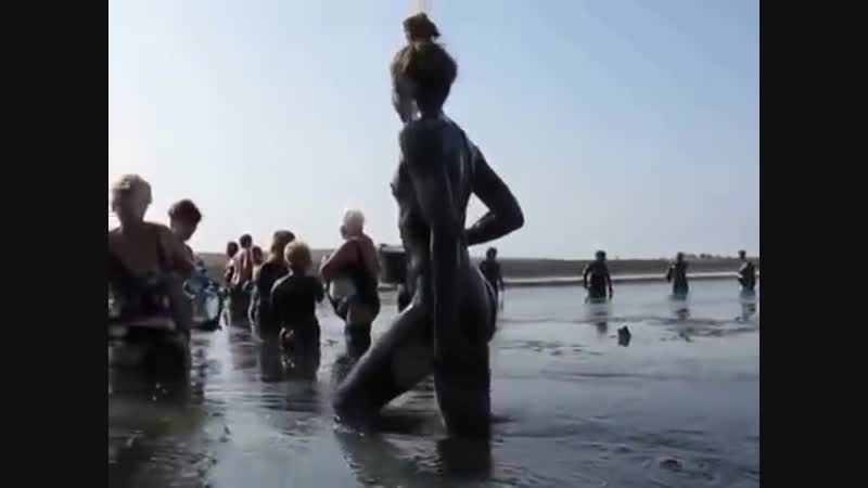 Обнаженная девушка принимает грязевые процедуры