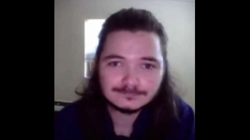 Загадочный длинноволосый мужчина не менее загадочно смотрит в камеру