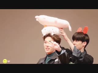 Yunho stacking plushies on top of mingi’s head