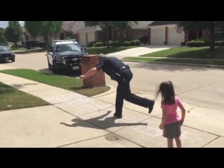 Police officer takes time on his lunch break to play hopscotch with a young girl