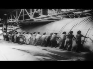 Women stitch an airship bag and inspect the completed bag using a spot light in t hd stock footage