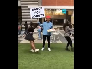 Guy offering donuts to people showcasing their dancing skills