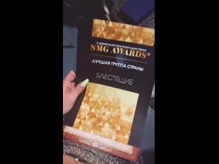 Сильвия золотова показывает награду премии "smg awards"