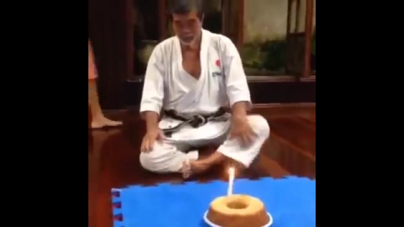 70 летний мастер карате задувает свечу на торте в свой день рождения