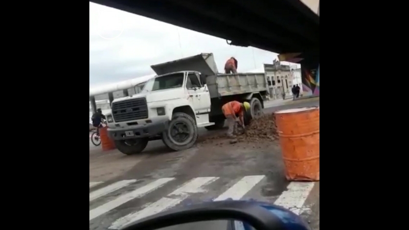 В мексике двое рабочих активно разгружают/загружают кузов машины