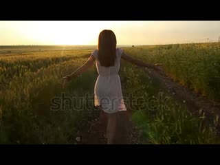 Stock footage beautiful young woman with vintage dress clothes running in rural countryside wheat field at sunset mp4
