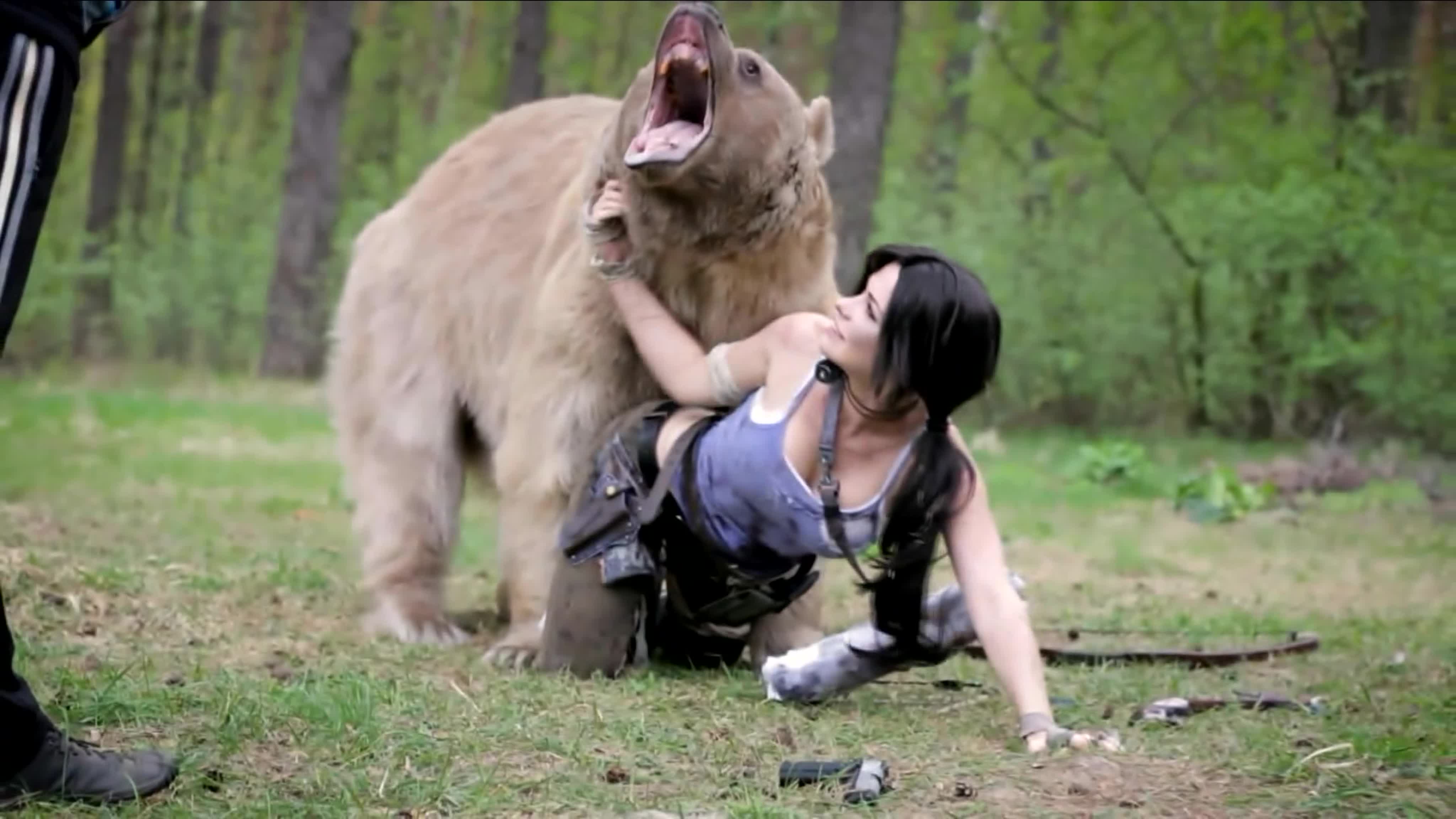 Beautiful girl poses with a bear for lara croft cosplay