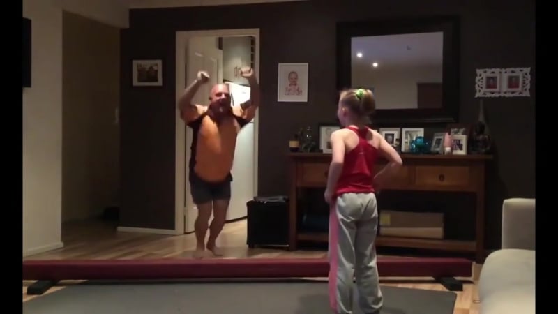 Отец копирует гимнастические упражнения дочери гимнастки