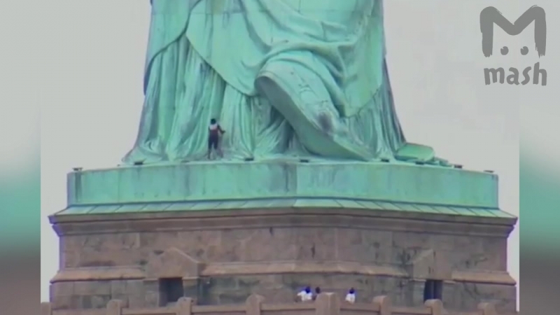 Женщина забралась на статую свободы