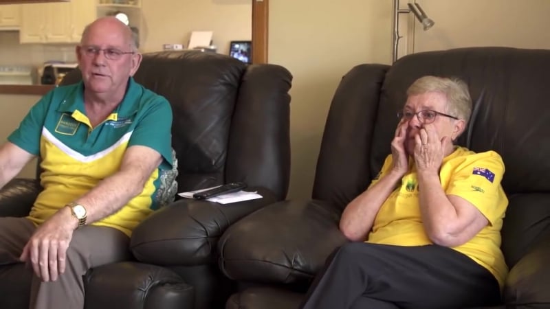 Дедушка и бабушка смотрят, как внук выигрывает золотую медаль на олимпиаде