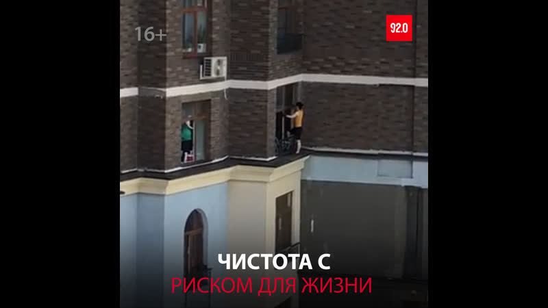 Женщина моет окно, рискуя упасть с высоты москва fm