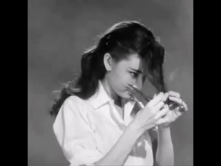 Audrey hepburn cutting her hair in a promo for "roman holiday" (1953)