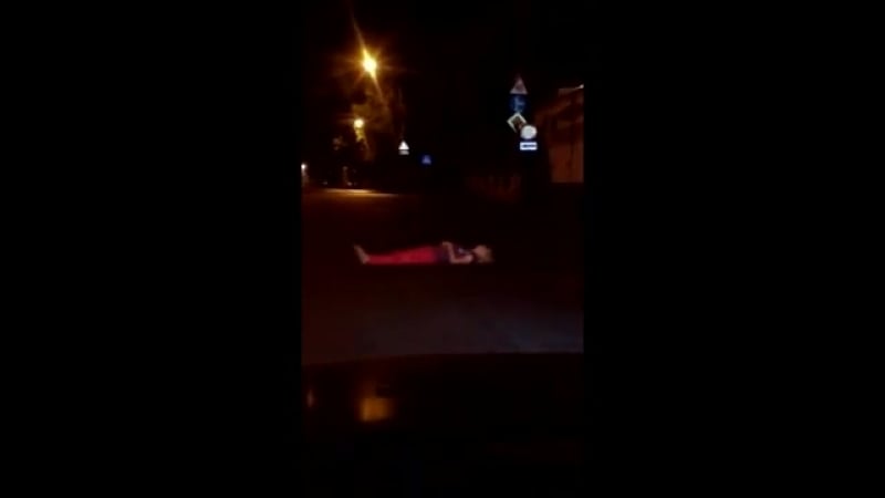 Девушка лежит на асфальте поперек дороги, не давая автомобилистам проехать воронеж