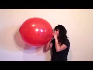 Cute girl bursting large punch balloon