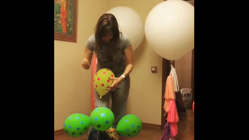 Девушка лопает шарики после праздника